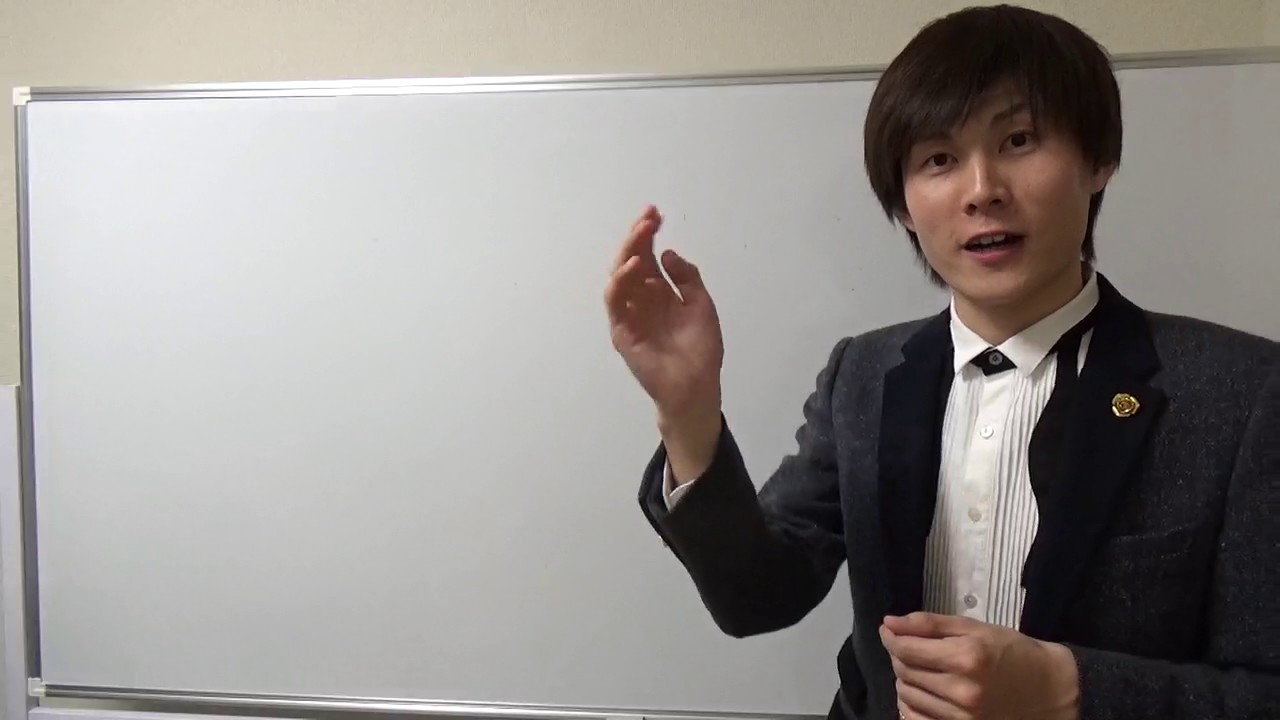 ホワイトボード前でスーツ姿の本人が片手を挙げて解説する（結果を出している人から学ぶ）