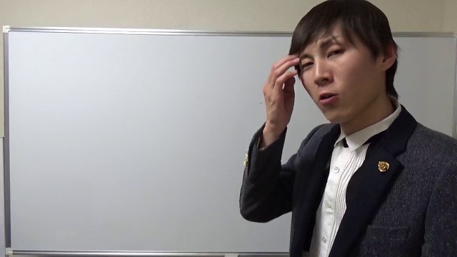 ホワイトボード前で頭に手を当て話す本人（動画「東京のイベント規制がヤバい」より）