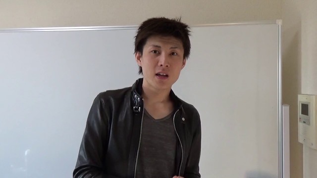 ホワイトボード前で革ジャン姿の本人が正面を向き話す（動画「夏目の立ち回りを公開します【パチスロ】【スロット】」より）