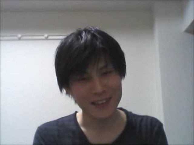縞シャツで正面を見る本人の顔アップ（動画「ダサい人ほどパチスロは損をする」より）