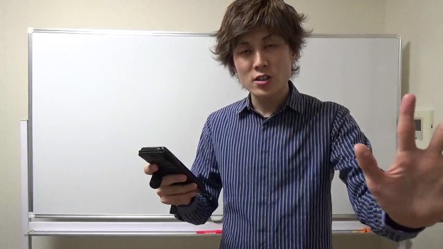 スマホを持ちホワイトボード前に立つ本人（動画「パチスロ業界で最強になれる考え方【パチスロ】…」より）