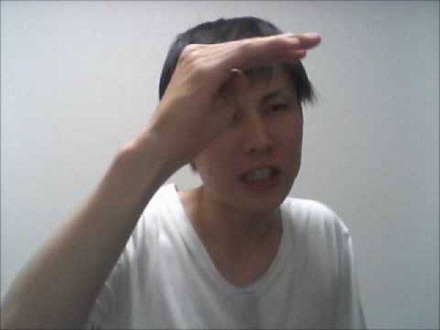 白Tシャツで額に手をかざす本人（動画「伝説のスーパーサイヤ人になってもらいます【パチスロ】」より）