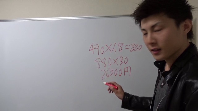 ホワイトボードに「490×1.8=880」等の計算式を書く革ジャン姿の本人（動画「スロマガの旅打ちに物申す【パチスロ】【スロット】」より）